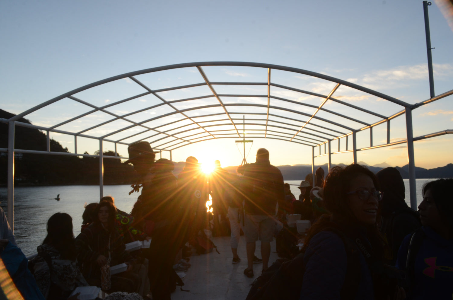 People on a boat at sunset with a metal canopy