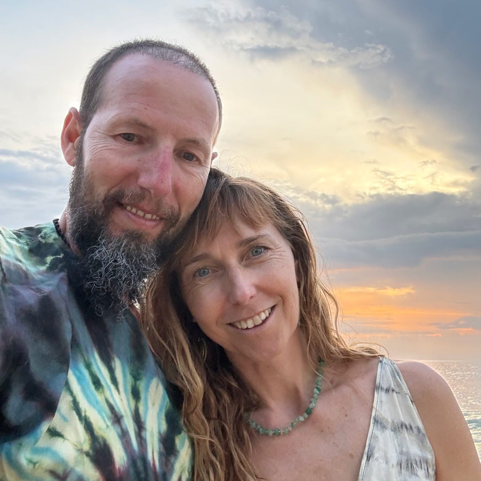 Keith's Cacao practitioner Ditte and husband Shaul,i posing together with a sunset or sunrise in the background