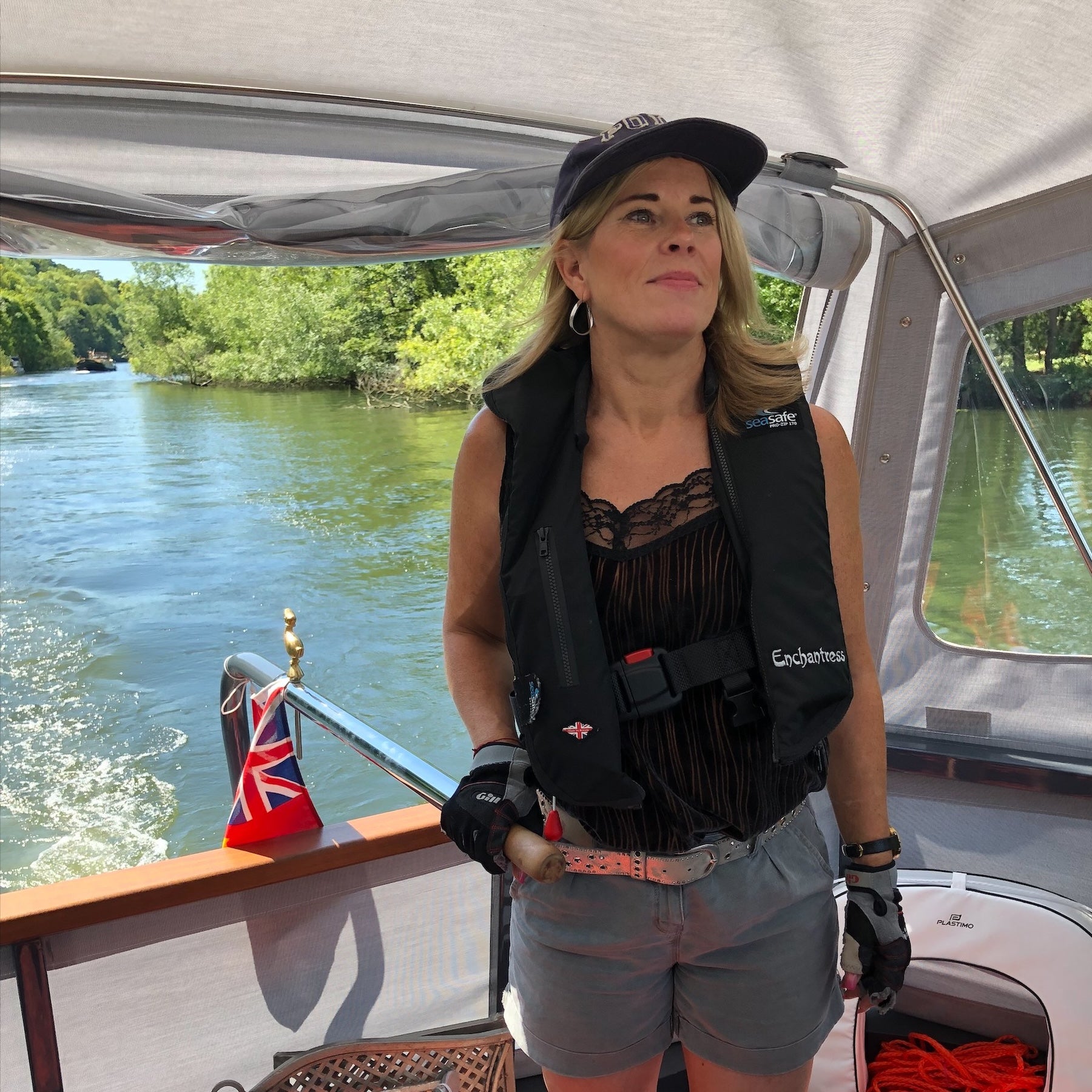 Woman on a boat wearing a life jacket with a scenic background